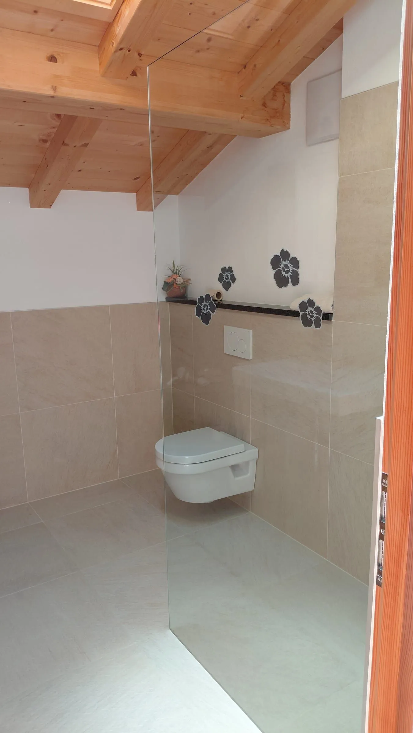 Badezimmer mit Wand-WC und Naturstein-Fliesen
