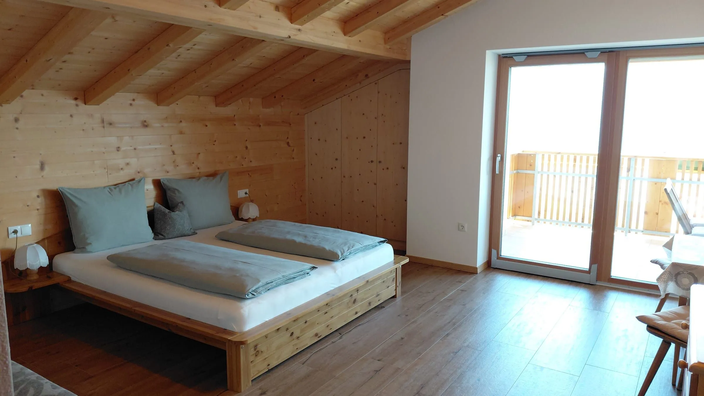 Schlafzimmer mit Panoramafenster und Bergblick
