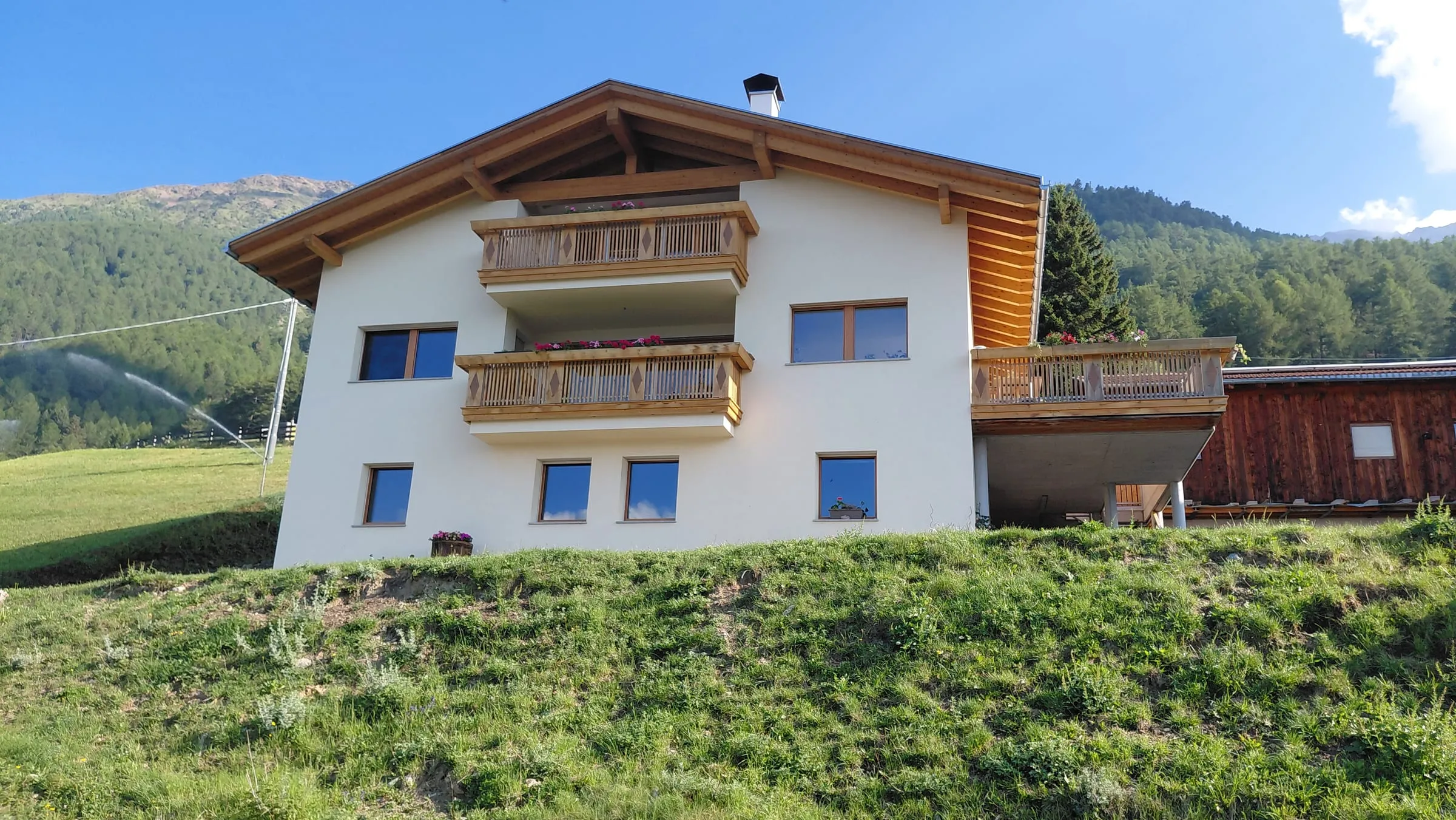 Der Frinighof am sonnigen Berghang oberhalb von Tanas