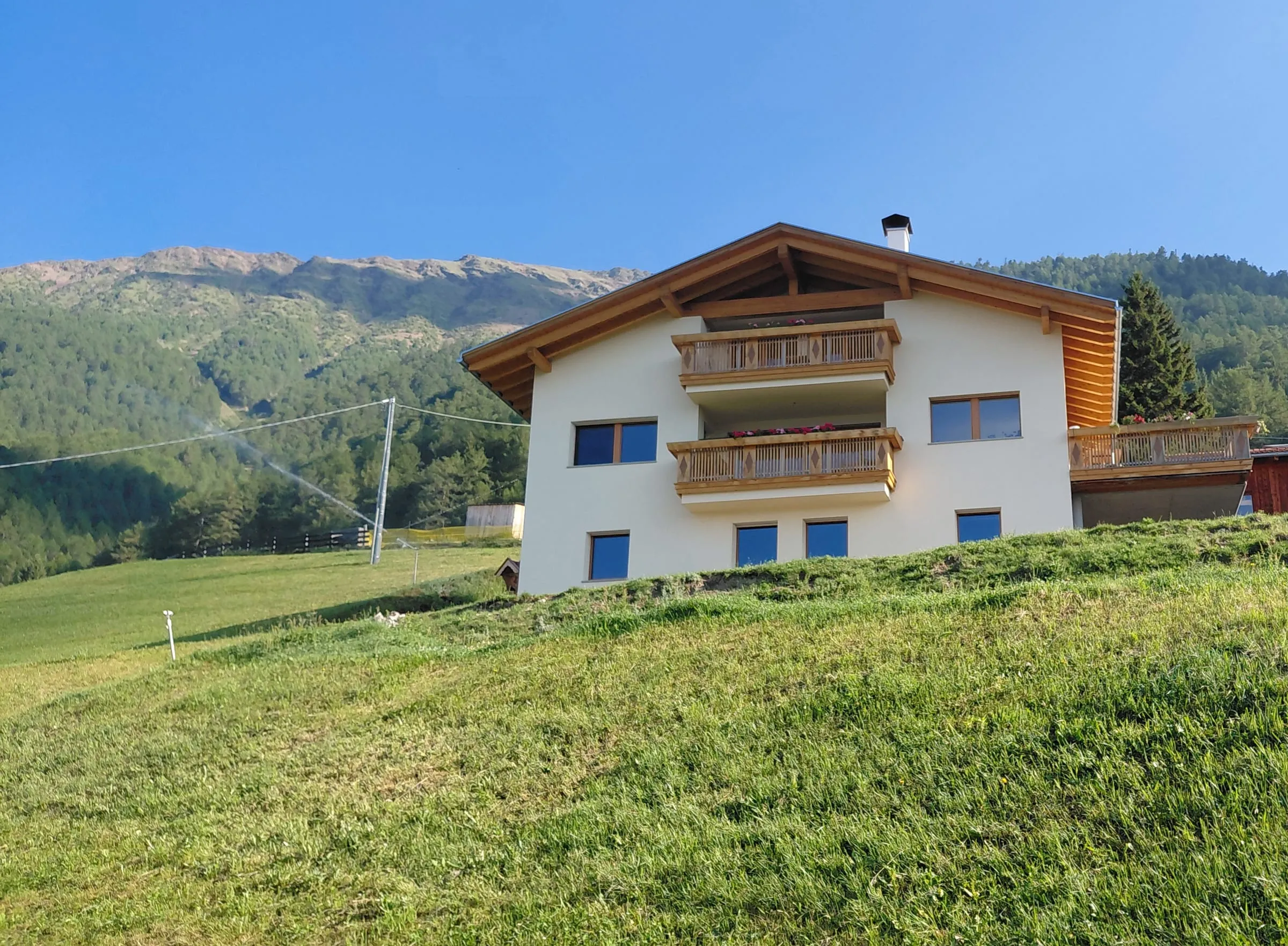 Bergbauernhof inmitten grüner Wiesen über dem Vinschgau
